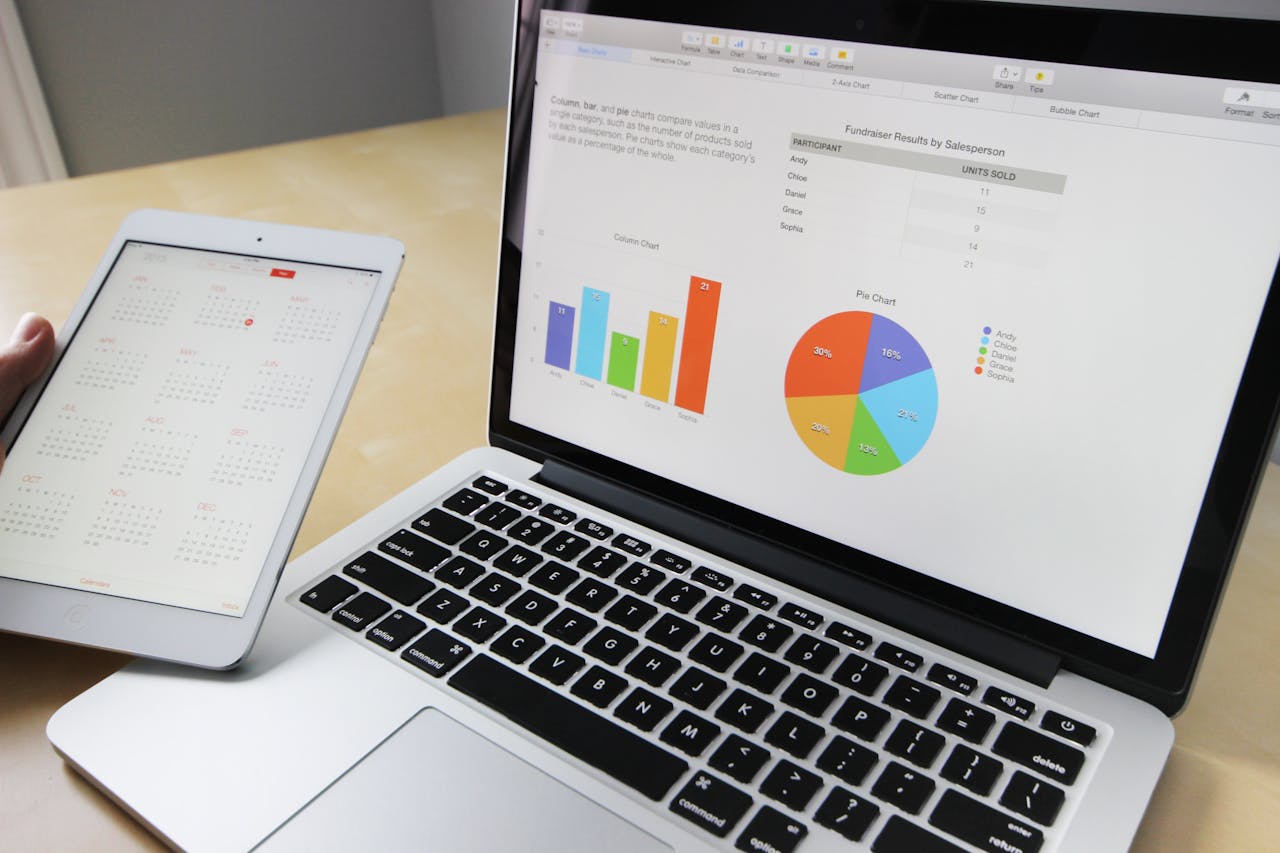 fitness-service-01 Laptop displaying charts and graphs with tablet calendar for data analysis and planning.